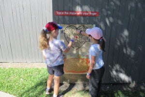 Two girls solving finger maze at Amaze World.