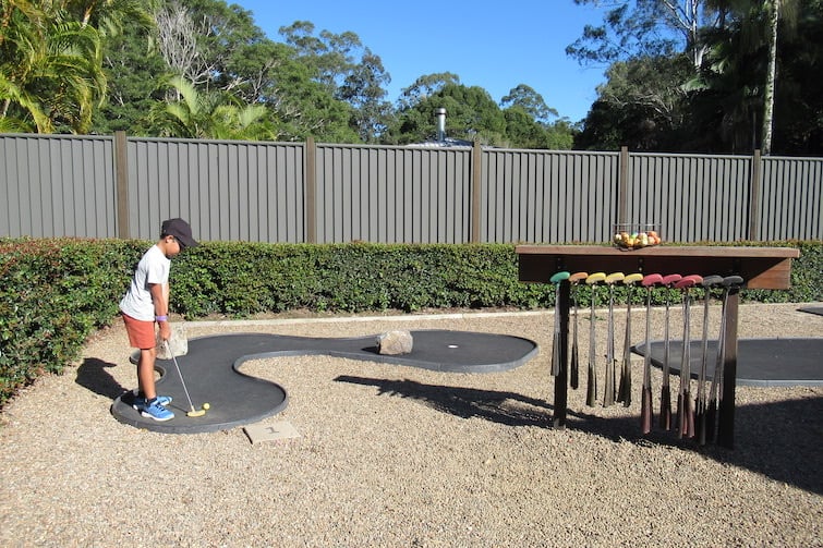Boy playing mini golf at Amaze World.