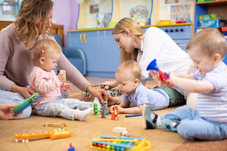 Music Beat mothers with babies on floor playing.